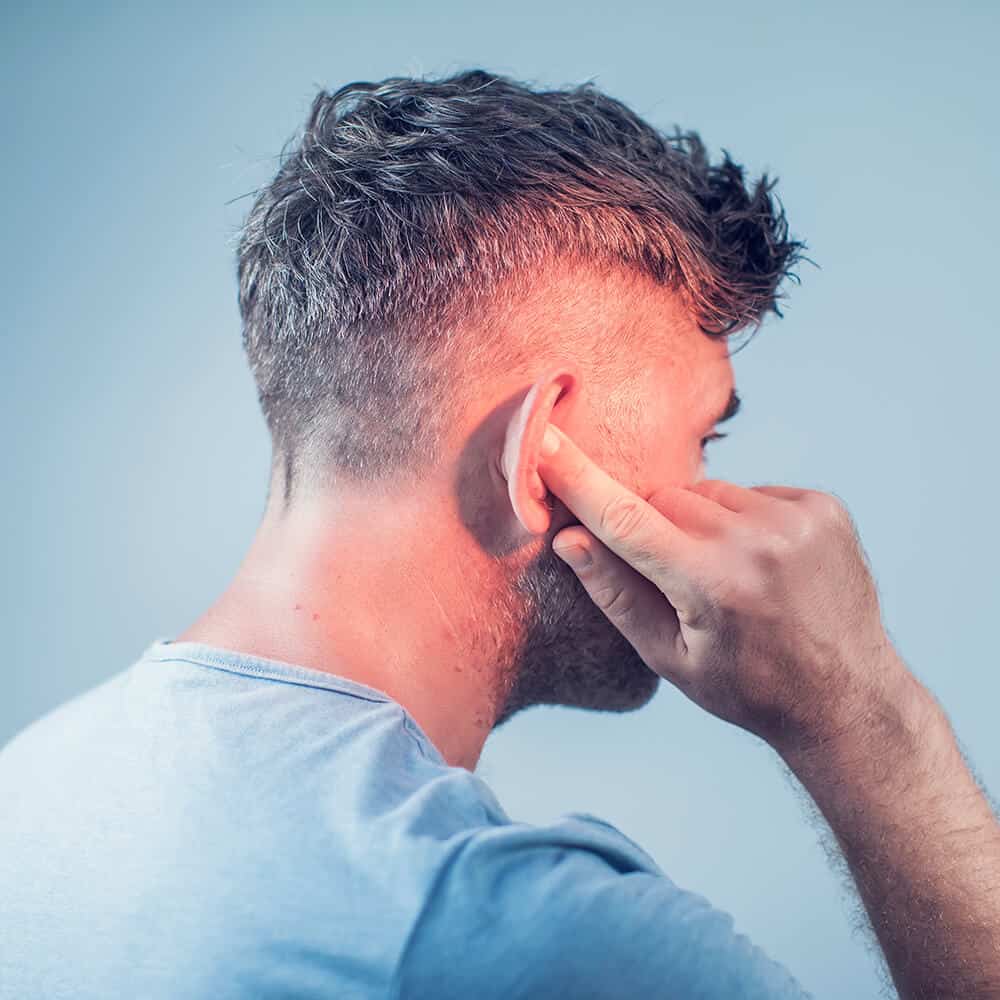 Tinnitus Treatment | A man touching his right ear