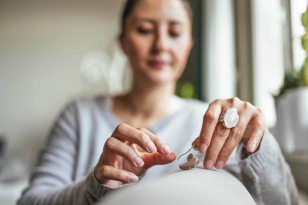 woman holding hearing aid